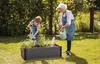 A grandmother and grandchild watering plants in a raised garden bed. Náhľad obrázku produktu