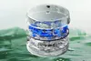 A transparent cylindrical container with blue and clear liquid inside, set against a green and white background. Produktbild-Vorschau