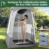 A woman is showering inside a portable shower tent outdoors, with a wooden shelf unit nearby holding toiletries and towels. Produktbild-Vorschau