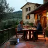A couple is dining on a patio at dusk, with a portable heater in the foreground. Produktbild-Vorschau