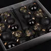 A box of black Christmas ornaments with gold detailing. Produktbild-Vorschau