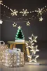 Christmas decorations including a light-up tree, gift boxes, and star lights. Produktbild-Vorschau