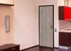 A door with a wood-grain pattern and a kitchen area with red cabinets. Produktbild-Vorschau
