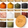 A collection of glass spice jars with bamboo lids, filled with various spices and herbs. Produktbild-Vorschau