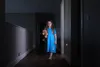 A young girl walks down a dark hallway holding a teddy bear. Náhľad obrázku produktu