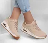 A pair of beige Skechers Uno Shimmer Away sneakers worn by a person, shown from the side against a white background. Produktbild-Vorschau