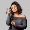 A woman is styling her hair with a hair straightener. Anteprima dell’immagine prodotto