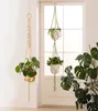Two macrame plant hangers with plants are displayed indoors, with a large monstera plant in the background. Produktbild-Vorschau