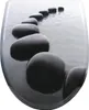 A line of smooth, dark stones arranged diagonally on a rippling water surface. Produktbild-Vorschau