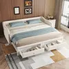 A white sofa bed with blue pillows and blankets is shown in a room with wooden walls and a patterned rug. Produktbild-Vorschau