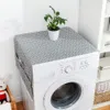 A washing machine with a patterned cover and a plant on top, placed in a laundry room setting. Podgląd zdjęcia produktu