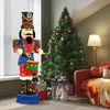 A decorated Christmas tree and a large illuminated nutcracker figure are set up in a living room. Podgląd zdjęcia produktu