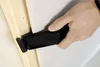 A hand is holding a black tool against a white surface and a wooden beam. Náhled obrázku produktu