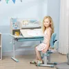A young girl sits at a children's desk and chair set. Produktbild-Vorschau