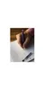 A hand holding a pen over a piece of paper with writing on it. Náhled obrázku produktu