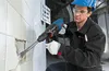 A construction worker is using a Bosch hammer drill to remove tiles from a wall. Náhled obrázku produktu