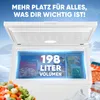 An open chest freezer with food items inside, set against a snowy mountain backdrop. Produktbild-Vorschau