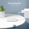 A white power bank is charging on a white table next to a potted plant, with a white charging brick plugged into a wall outlet in the background. Produktbild-Vorschau