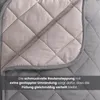 Close-up of a quilted blanket showing the diamond pattern and stitching. Produktbild-Vorschau