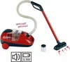 A toy Vileda vacuum cleaner with a red body and black accents, shown with its hose, wand, and floor head. There are also small white beads in a clear container and two battery icons. Produktbild-Vorschau