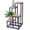 A multi-tiered plant stand with a plant and a statue on it, against a white background. Anteprima dell’immagine prodotto