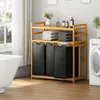 A laundry room with a bamboo laundry sorter, washing machine, and bathtub. Anteprima dell’immagine prodotto