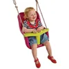 A baby sitting in a red and green baby swing. Produktbild-Vorschau