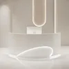 A modern, minimalist reception desk with a curved front and integrated lighting. Produktbild-Vorschau