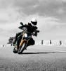 A person riding a motorcycle on a road. Podgląd zdjęcia produktu