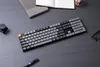 A keyboard and other office supplies are arranged on a dark wooden desk. Produktbild-Vorschau