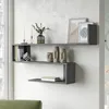 A modern living room with a grey concrete-effect wall-mounted shelf unit displaying decorative items and books. Produktbild-Vorschau