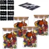 Four glass jars filled with candy, with chalk labels and a chalk pen nearby. Produktbild-Vorschau