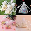 A collage of four images showing small white organza bags filled with different items. Produktbild-Vorschau