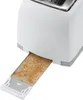 A close-up view of a white toaster with its crumb tray extended and filled with crumbs. Podgląd zdjęcia produktu