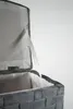 Close-up view of the inside of a grey woven laundry basket with its lid open. Podgląd zdjęcia produktu