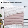 A quilt is hung on a wall-mounted drying rack on a balcony, with text indicating to open it up and let it ventilate. Produktbild-Vorschau
