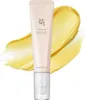 A tube of eye serum is shown with a smear of the product behind it. Voir les images du produit