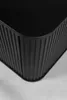 A close-up view of the corner of a black cabinet with vertical ribbed detailing. Anteprima dell’immagine prodotto