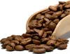 A wooden scoop filled with coffee beans, with some beans spilled out onto a white surface. Produktbild-Vorschau
