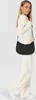 A woman is modeling a black hobo shoulder bag. Produktbild-Vorschau