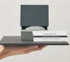 A hand holding a slate tray with a Guess watch box and guarantee card. Podgląd zdjęcia produktu