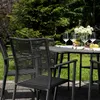 An outdoor dining set with a table and chairs, set in a garden. Produktbild-Vorschau