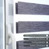 A close-up view of a window with a grey roller blind and a white window handle. Text overlays describe the features of the blind. Produktbild-Vorschau