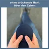 A person is holding a dark blue sock, showing its toe area. The background is blurred, showing legs in blue jeans. Produktbild-Vorschau