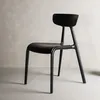 A black chair against a textured gray wall and a lighter gray floor. Podgląd zdjęcia produktu