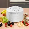 A white food dehydrator is placed on a wooden table, surrounded by various fruits and vegetables. Anteprima dell’immagine prodotto