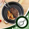 A person is using tongs to cook a steak and potatoes in a pan. Voir les images du produit