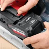 A close-up shot of a person's hands attaching a battery to a power tool. Voir les images du produit