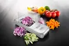 A kitchen slicer with various vegetables chopped around it. Náhled obrázku produktu