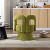 A green armchair is placed in a living room setting, with a cabinet and decor in the background. Produktbild-Vorschau